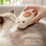 Beige electric spray grooming brush being used gently on a cat