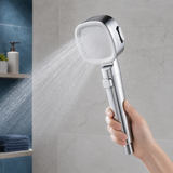 Silver three-mode filtered shower head running in a modern bathroom