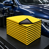 Ten-pack of 30 by 30 cm yellow and charcoal microfiber car towels on a detailing bench