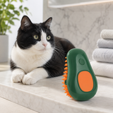 Green avocado-shaped pet spray grooming brush beside a black-and-white cat